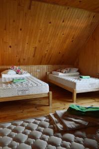 two beds in a room with a wooden ceiling at Beibuki in Naujene