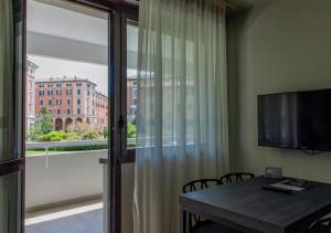 a room with a table and a television and a window at Astoria Living Apartments in Bologna