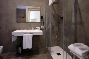 ein Bad mit einer Dusche, einem Waschbecken und einem Spiegel in der Unterkunft Napoli Class in Neapel