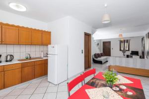 a kitchen with a red table and a white refrigerator at Maria's House in Potamiá