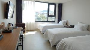 Postel nebo postele na pokoji v ubytování Jeju Noblesse Hotel