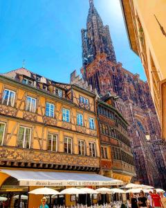 duży budynek z wieżą zegarową w tle w obiekcie Maison Kammerzell - Hotel & Restaurant w Strasburgu