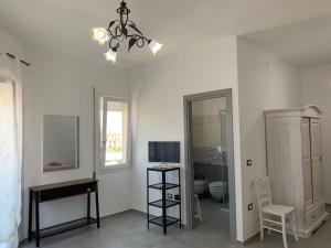 een kamer met een spiegel, een tafel en een kroonluchter bij B&B Centrale in Tortolì
