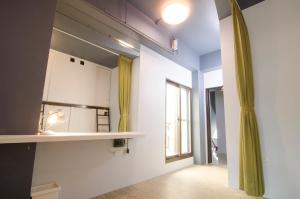 een kamer met een keuken met een wastafel en een raam bij Flying Backpacker in Yilan