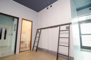 una habitación con una escalera junto a una pared en Flying Backpacker, en Yilan City