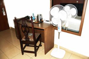 Cette chambre comprend un bureau avec un ventilateur et une chaise. dans l'établissement Jamia Central Hotel, à Nairobi