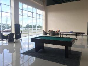 ein Billardtisch in einem Raum mit Stühlen in der Unterkunft Heaven Suites, Tagaytay Condominium, Wind Residences in Tagaytay