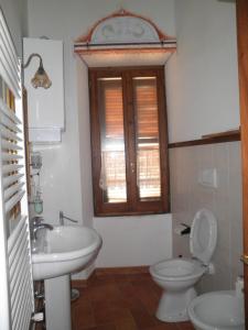 a bathroom with a sink and a toilet and a window at Palazzetto Leonardi in San Polo dei Cavalieri