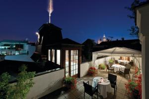 a rooftop patio with a table and chairs at night at Hotel Gródek in Krakow