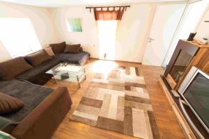 a living room with a couch and a television at Ferienhaus Salmtal Himmerod in Großlittgen