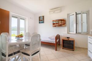 a kitchen and dining room with a table and a bed at Apartments Lukrecia in Neum