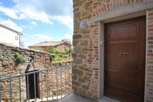 une porte en bois sur un mur de briques à côté d'un garage dans l'établissement appartamento di classe nel castello di Panicale, à Panicale