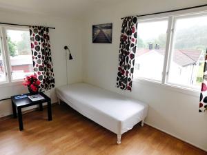 a small room with a bed and two windows at Hovstø in Seljord