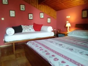 2 camas en una habitación con paredes rojas en B&B La Capanna Rossa, en San Romolo