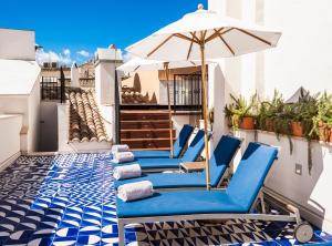 
a blue and white striped lounge chair sitting under an umbrella at Hotel Cort in Palma de Mallorca
