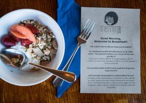 a bowl of cereal with fruit and a menu at Merrijig Inn in Port Fairy