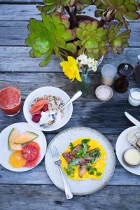 einen Tisch mit Teller mit Lebensmitteln und Obst in der Unterkunft Merrijig Inn in Port Fairy