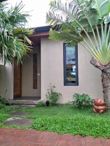 a house with a palm tree in front of it at 墾丁裡小路包棟Villa in Nanwan