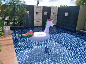 a pool with a unicorn and a float in the water at 墾丁裡小路包棟Villa in Nanwan