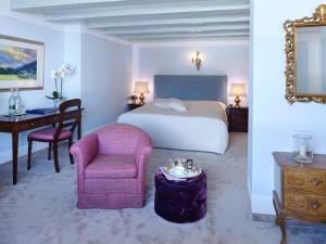 1 dormitorio con 1 cama, 1 silla y 1 mesa en Thurnher's Alpenhof, en Zürs am Arlberg