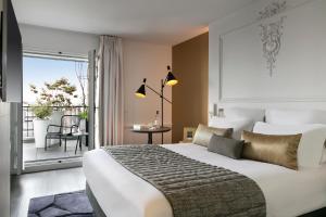 a bedroom with a large bed and a balcony at La Clef Champs-Élysées Paris by The Crest Collection in Paris