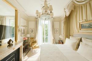 a bedroom with a bed and a fireplace and a chandelier at Ritz Paris in Paris