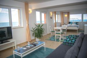 a living room with a couch and a tv and a table at Casa Eden in Costinesti