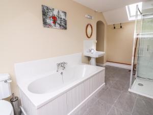 une salle de bain blanche avec une baignoire et un lavabo dans l'établissement Penlone Cottage, à Rhayader 21 autres photos