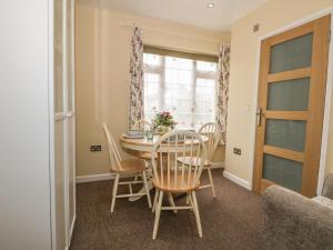 a dining room with a table and chairs and a window at Beau Annexe in Ringwood