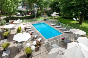 an overhead view of a pool with chairs and umbrellas at ibis Styles Besançon in Besançon