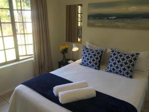 a bedroom with a large bed with blue and white pillows at Bishops GuestHouse in Eshowe