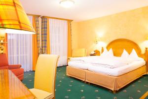 ein Hotelzimmer mit einem großen Bett und einem Tisch in der Unterkunft Hotel Wilder Mann in Königstein in der Oberpfalz