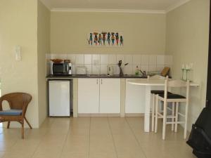 a kitchen with white cabinets and a table and a microwave at Springfontein Wine Estate Stanford River Lodge in Stanford