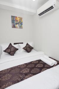 a bed with black and white sheets and pillows at K VILA HOTEL in Sungai Petani +11 photos