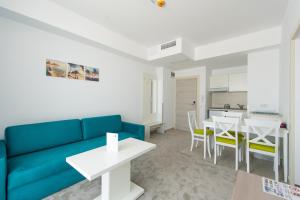 a living room with a blue couch and a table at ZIP Apartments in Mamaia