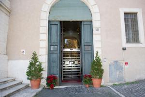 an entrance to a building with two potted plants at Domus Sessoriana in Rome