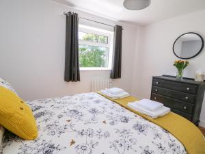 1 dormitorio con 1 cama con tocador y ventana en Owl Cottage, en Llandrindod Wells