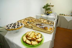 - une table avec 2 plateaux de pain et des viennoiseries dans l'établissement Domus Sessoriana, à Rome
