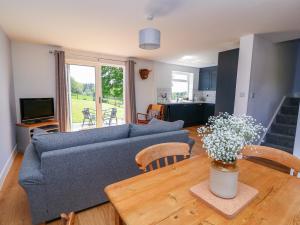 sala de estar con sofá azul y mesa de madera en Owl Cottage, en Llandrindod Wells