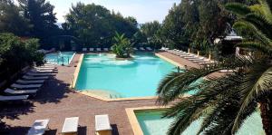 een uitzicht over het zwembad met ligstoelen bij Villaggio Dei Fiori in Sanremo