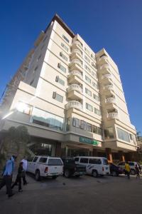 a large building with cars parked in front of it at Hotel Essencia in Dumaguete