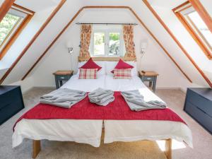 a bedroom with a large bed with red pillows at The Barn at Waen y Ffynnon in Ruthin