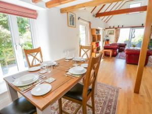 a dining room with a wooden table and chairs at The Barn at Waen y Ffynnon in Ruthin