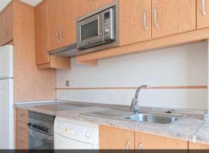 a kitchen with a sink and a microwave at Apartamento zona residencial el palmar in El Palmar