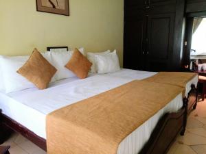 1 cama grande con sábanas y almohadas blancas en Kithulgala Rest House, en Kitulgala