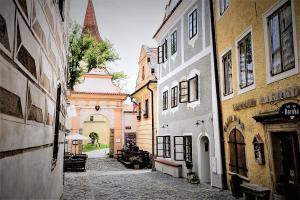 an alley in an old town with buildings at Monastery Garden Bistro & Rooms in Český Krumlov