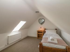 a attic bedroom with a bed and a heart mirror at Highcroft in Belper