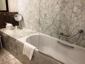 a bathroom with a tub and a glass shower at The Xara Palace Relais & Chateaux in Mdina