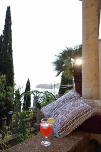 a drink in a glass sitting on a ledge with a pillow at Villa Matilda in Dubrovnik