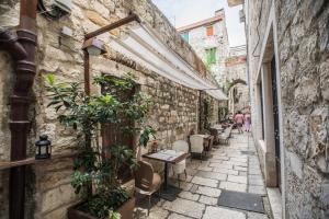 un callejón en un casco antiguo con mesas y plantas en Apartment Dioclessima, en Split